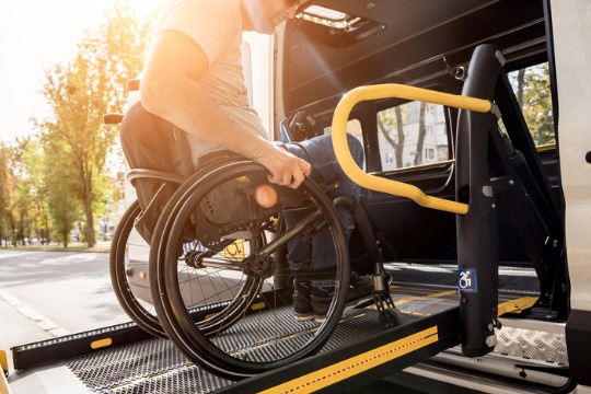 a-man-in-a-wheelchair-on-a-lift-of-a-vehicle-for-people-with-disabilities 540x360